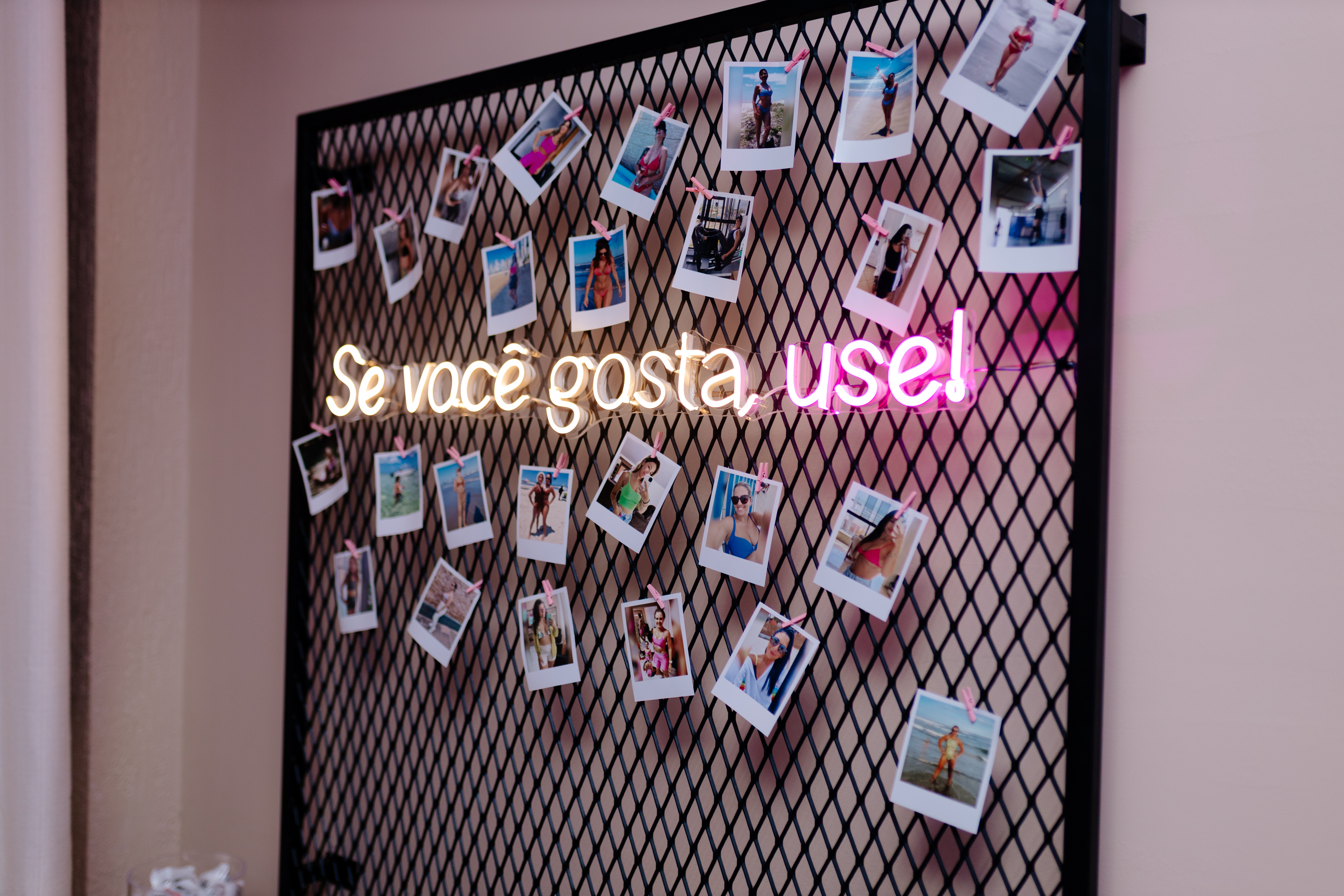Mural das musas com fotos polaroide das clientes da PB